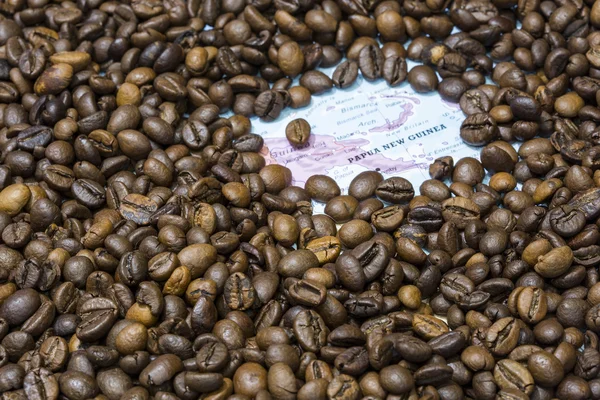 Map of Papua New Guinea under a background of coffee beans — Stockfoto