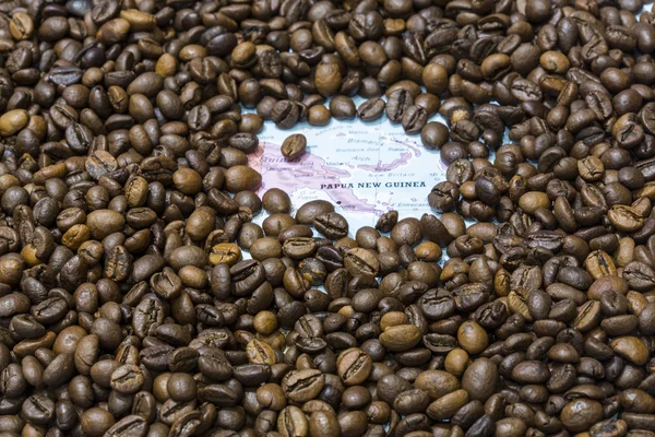 Map of Papua New Guinea under a background of coffee beans — Stockfoto