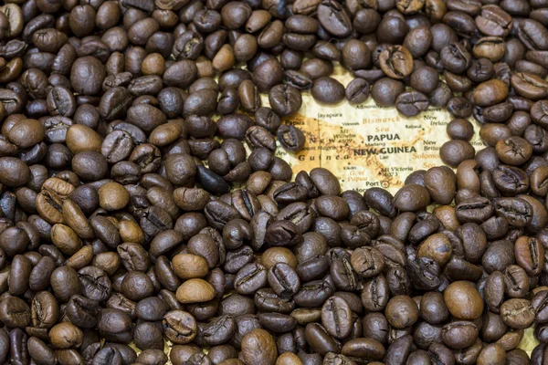 O mapa de Papua-Nova Guiné sob um fundo de grãos de café — Fotografia de Stock