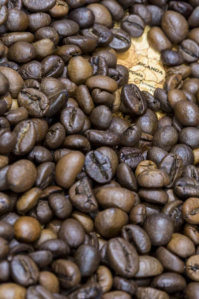 Map of Uganda under a background of coffee beans — Stockfoto