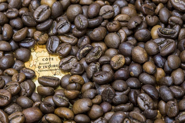 Map of Ivory Coast under a background of coffee beans — Stockfoto