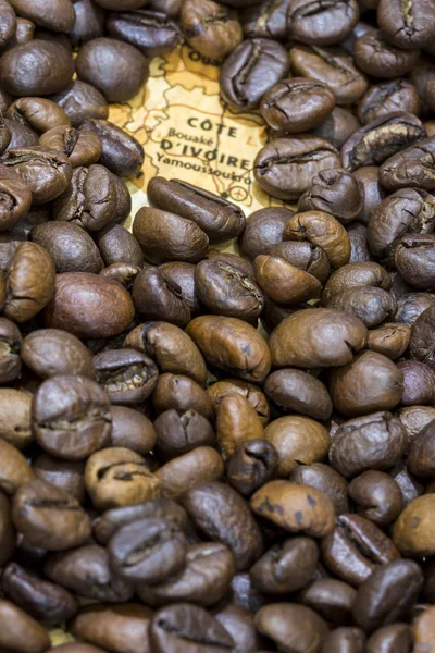 Map of Ivory Coast under a background of coffee beans — Stockfoto