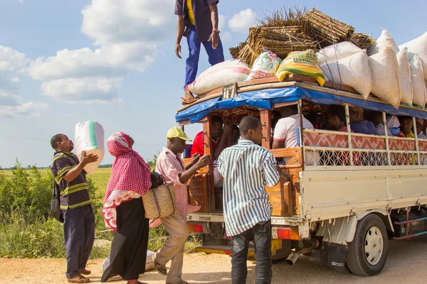 Personas que cargan carga y equipaje en un vehículo de transporte público local — Foto de Stock