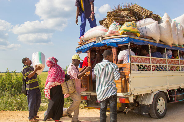 People loading cargo and luggage on local public transport vehicle