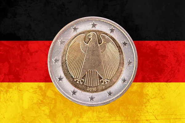 Німецькі монети два євро з прапором Німеччини як тло — стокове фото