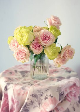 Açık arkaplanda pembe güller olan yakın plan çiçek kompozisyonu. Yumuşak odak.