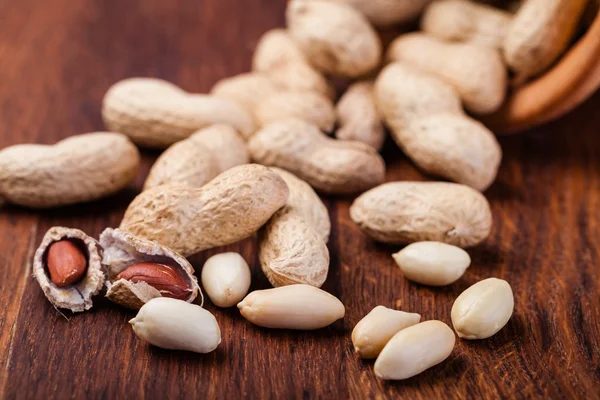 Erdnüsse isoliert auf einem Holztisch — Stockfoto