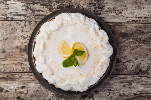 Лимонный пирог на тарелке украшенной лимонами — стоковое фото