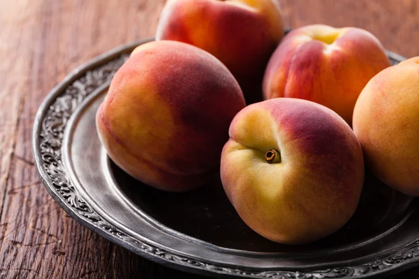 Peach on an iron plate — Stock Photo, Image