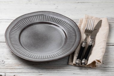 Masa ayarı. Tabak, bıçak ve çatal tahta bir masada.