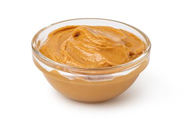 Beyaz arka planda izole edilmiş cam kase fıstık ezmesi.