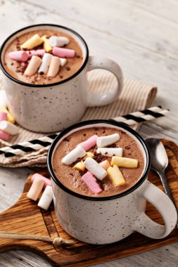 Tahta arka planda bir fincanda kremalı sıcak çikolata.