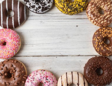 Ahşap bir arka planda çeşitli donutların üst görünümü