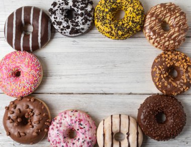 Ahşap bir arka planda çeşitli donutların üst görünümü