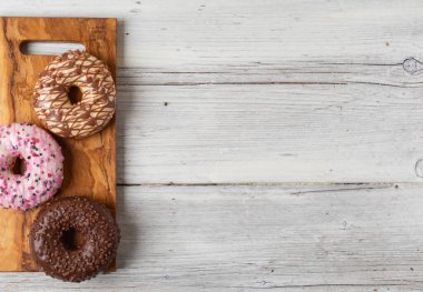Ahşap bir arka planda çeşitli donutların üst görünümü