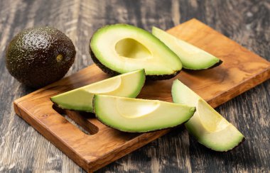 Avokado ahşap bir masada izole edilmiş.