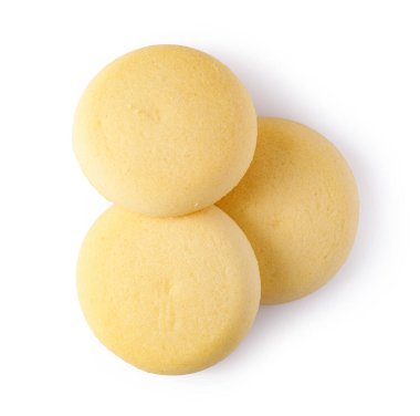 Üç küçük kek, ya da kurabiyeler, istiflenmiş ve sade bir arka plana yerleştirilmiş.