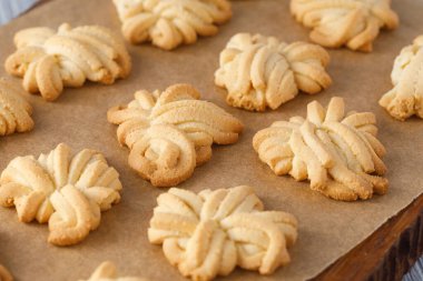 Tereyağlı kurabiyeler parşömen kağıdında soğuyor. Pişirdikten sonra, eğlenmeye hazır.