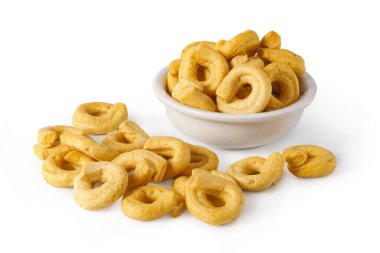 İtalyan taralli bisküvileri beyaz bir kase içinde, beyaz arka plan üzerine serpiştirilmiş.