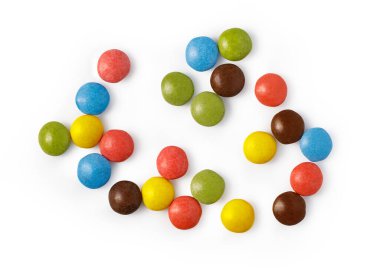 Parlak şeker kaplı çikolata şekerler saf beyaz bir yüzey üzerinde desen oluşturuyor.