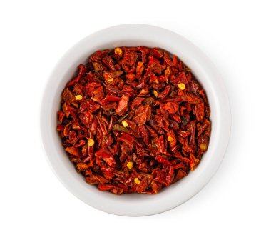 Kurutulmuş kırmızı biber taneleri yemek ve baharat için beyaz bir kâseyi dolduruyor.