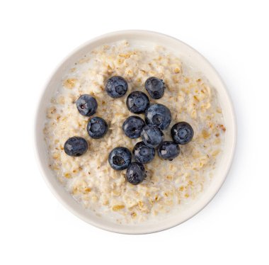 Beyaz arka planda izole edilmiş taze yaban mersini ve sütle bir kasede yulaf lapası.