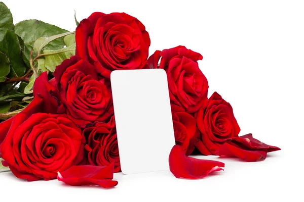 Rosas rojas con una etiqueta de regalo en blanco aislada sobre fondo blanco — Foto de Stock