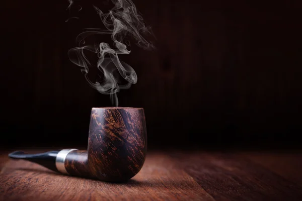 Smoking pipe on a wooden table — Stock Photo, Image