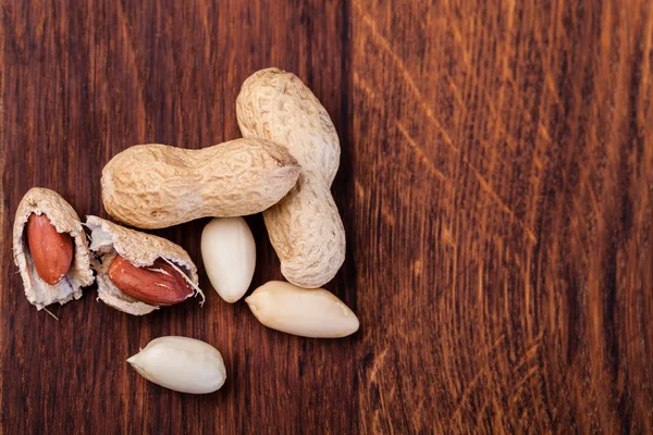 Erdnüsse isoliert auf einem Holztisch — Stockfoto