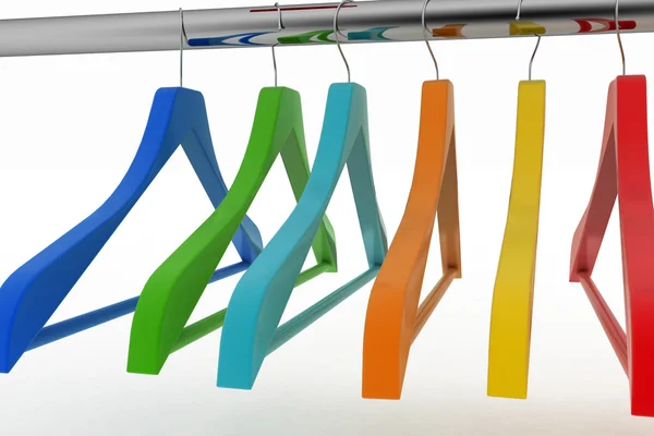 Row of color coat hangers on metal clothes rail — Stock Photo, Image