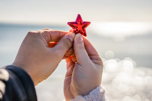 Zwei Hände mit Christbaumschmuck — Stockfoto