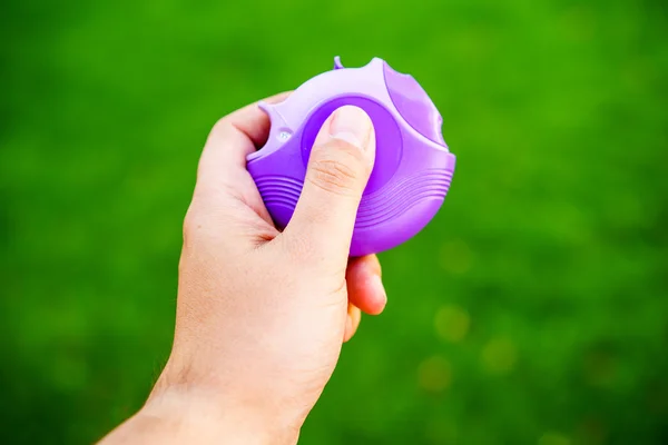 Mão segurando inalador violeta contra de fundo verde — Fotografia de Stock