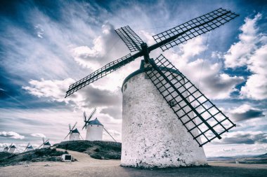 Consuegra, Ciudad Real, İspanya 'da bulutlu gökyüzünün arka planına yerleştirilen kırsal yel değirmeni.
