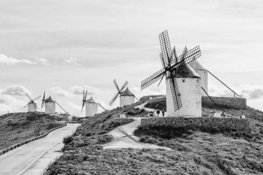 Consuegra, Ciudad Real, İspanya 'daki yel değirmenlerinin yakınındaki kırsal yolun siyah beyaz panoramik görüntüsü..