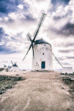 Consuegra, Ciudad Real, İspanya 'da bulutlu gökyüzünün arka planına yerleştirilen kırsal yel değirmeni.