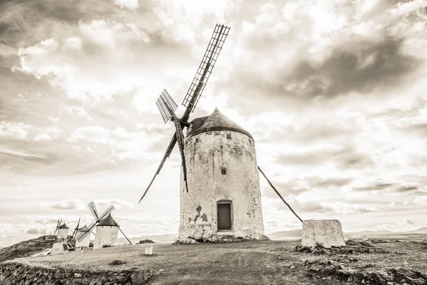 Consuegra, Ciudad Real, İspanya 'daki yel değirmenlerinin yakınındaki kırsal yolun siyah beyaz panoramik görüntüsü..