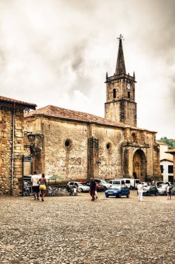 COMILLAS, CANTABRIA, SPAIN - 31 AĞUSTOS, 2016: Bulutlu gökyüzüne karşı taştan yapılmış ortaçağ kulesi