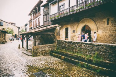SANTILLANA DEL MAR, CANTABRIA, İSPAN - 31 AĞUSTOS, 2016: Eski binalarla asfalt caddelerde yürüyen turistler.