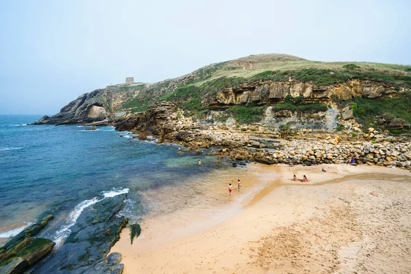 Santa Justa Beach Cantabria スペイン 2016 水の中で泳ぐ観光客と岩の多い土地で牧歌的な湾の景色 — ストック写真