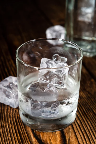 Vaso de vodka sobre mesa de madera —  Fotos de Stock