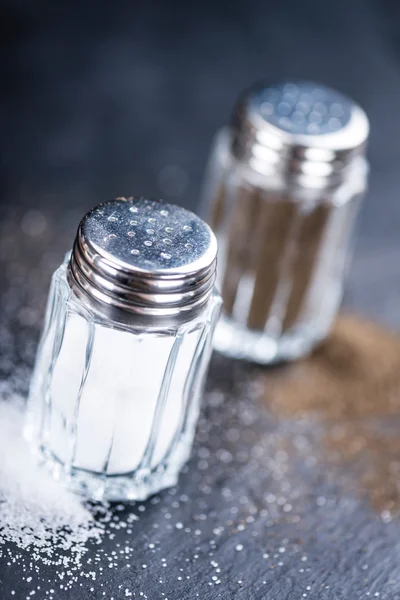 Skiffer platta med Salt och peppar Shakers — Stockfoto