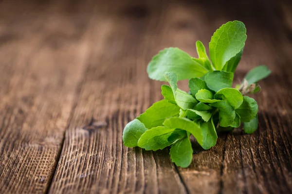 Dřevěný stůl s Stevia listy — Stock fotografie