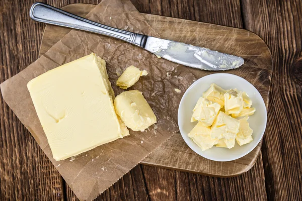 Stukken van boter op houten achtergrond — Stockfoto