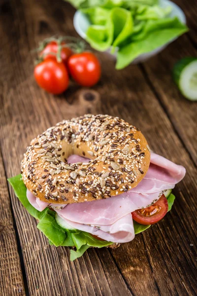 Table en bois avec jambon Bagel — Photo