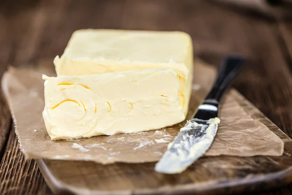 Stukje boter op houten achtergrond — Stockfoto