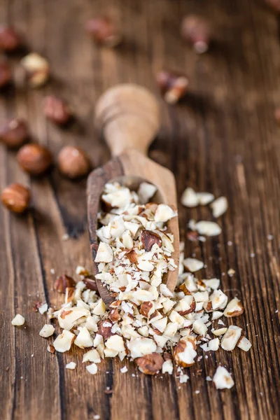 Wooden table with chopped Hazelnuts — Stock Photo, Image