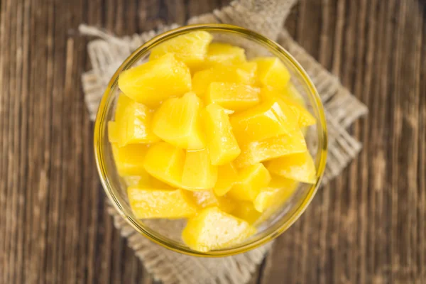 Canned Peaches on vintage wooden background — Stock Photo, Image