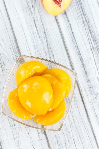 Canned Peaches on wooden background