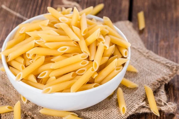 RAW Penne på trä bakgrund — Stockfoto