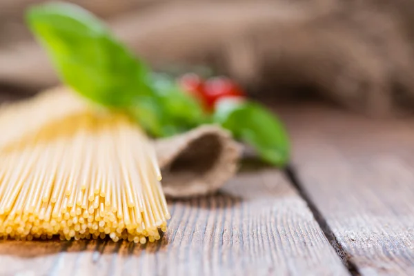 Raw Spaghetti with basil on wood — Stock Photo, Image